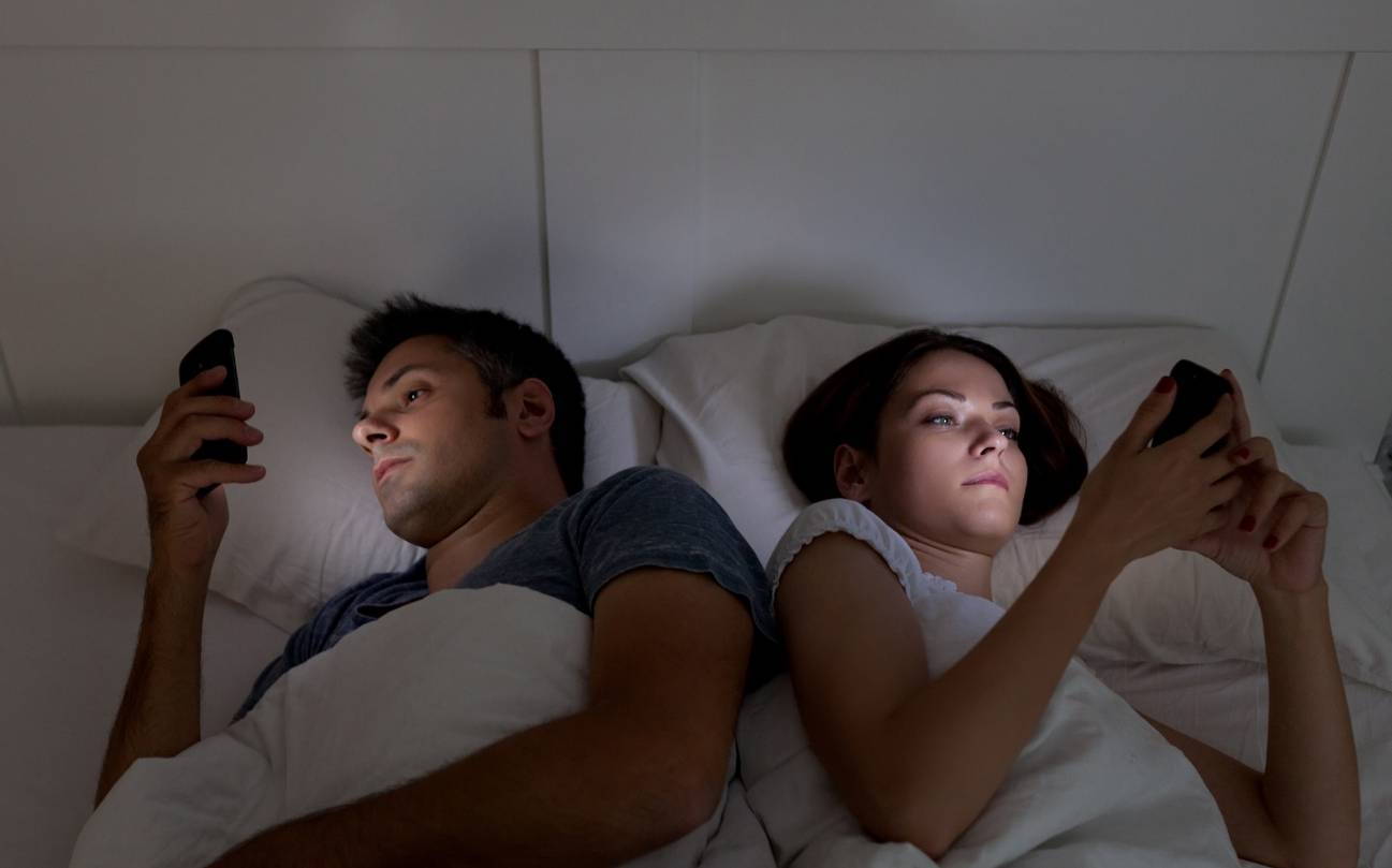 Pareja en la cama con celulares Pareja Pareja en la cama Pareja con celulares