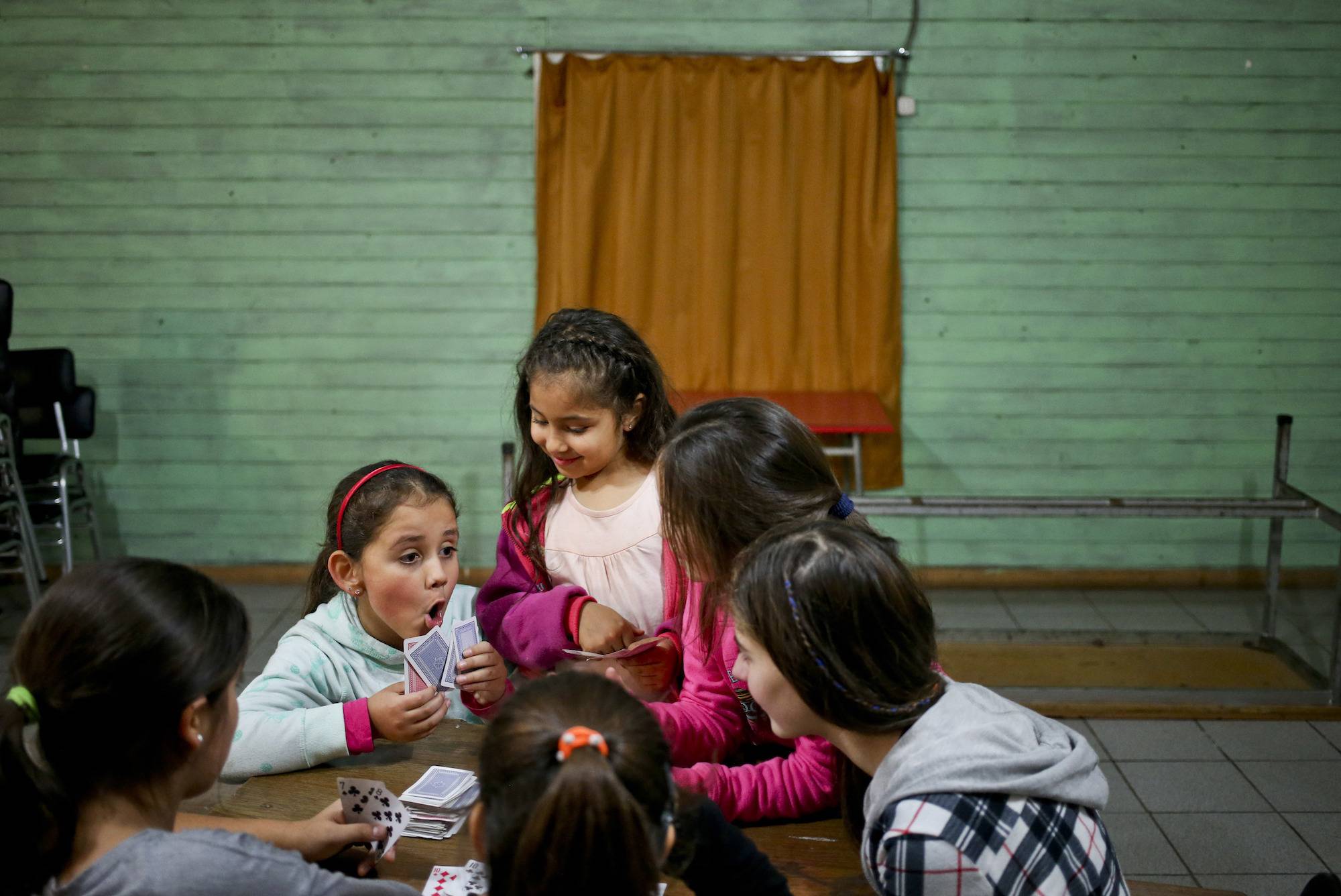 En esta imagen del 30 de de junio de 2017, la niña transgénero Selenna, a la izquierda, juega a las cartas durante un receso con otras niñas en una clase de danza en su centro comunitario en Santiago de Chile. La madre de Selenna, Evelyn Silva, dijo que h