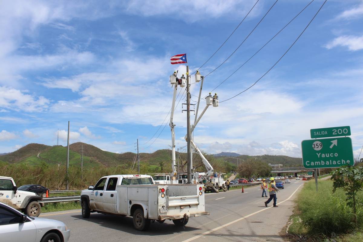 Empleados de la AEE colocaron una bandera de Puerto Rico al tope de un poste de la Autoridad en la carretera #2 en Yauco. / Foto: Miguel Dejesús