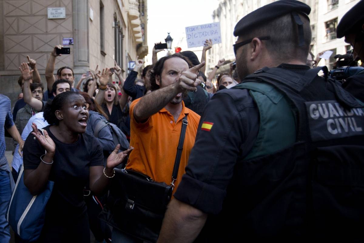 Manifestantes tratan de detener el auto que transporta a Xavier Puig, un alto funcionario del gobierno catalán, arrestado por la Guardia Civil en Barcelona, España, el miércoles 20 de septiembre de 2017. / AP