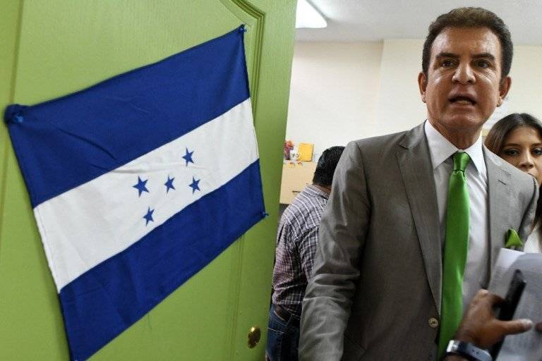 Salvador Nasralla junto a una bandera de Honduras