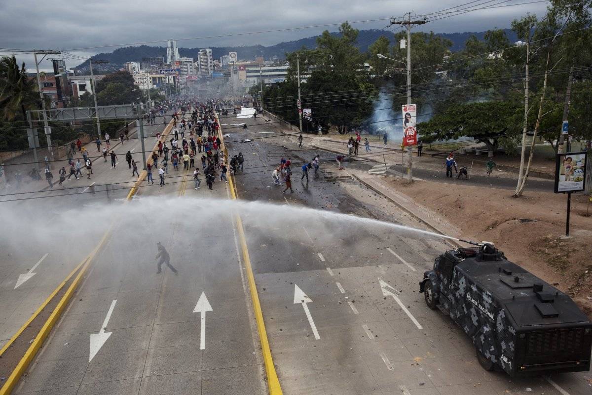 La policía lanza agua para dispersar a seguidores del candidato presidencial opositor Salvador Nasralla, reunidos cerca del lugar donde los votos de los comicios presidenciales están resguardados en Tegucigalpa, Honduras. (AP Foto/Rodrigo Abd)