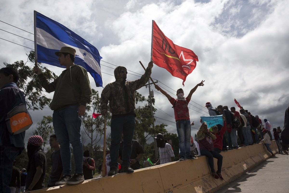 Seguidores del candidato opositor Salvador Nasralla gritan consignas contra el gobierno cerca del lugar donde se guardan los votos de los pasados comicios presidenciales en Tegucigalpa, Honduras. (AP Foto/Rodrigo Abd)