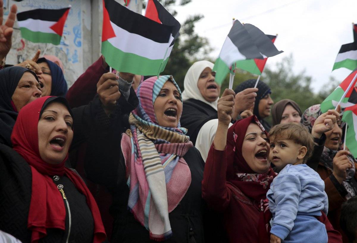 Las mujeres agitan banderas palestinas y corean lemas durante una protesta en la Plaza del Soldado Desconocido, en la ciudad de Gaza, el miércoles 6 de diciembre de 2017. / Adel Hana-AP