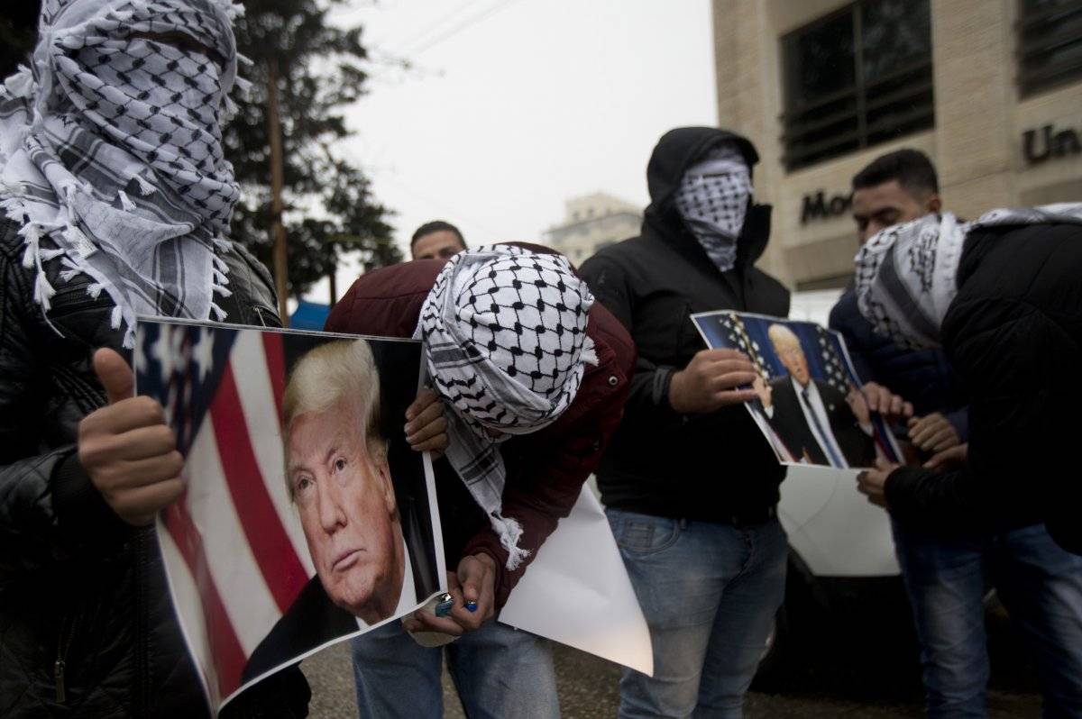 Los palestinos sostienen carteles del presidente estadounidense Donald Trump durante una protesta en Cisjordania, ciudad de Ramallah, el miércoles 6 de diciembre de 2017. / Majdi Mohammed-AP
