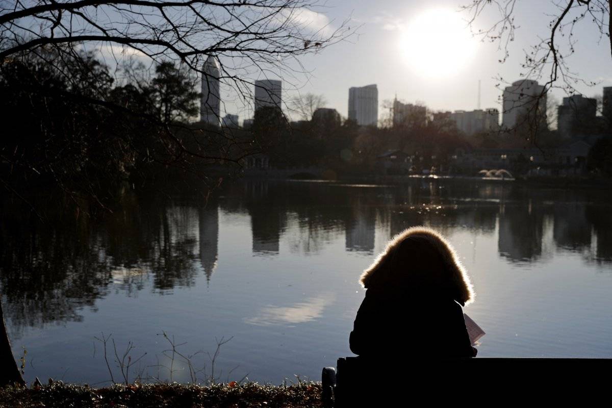 Una persona está sentada con su abrigo invernal mientras observa los edificios de Atlanta, el martes 2 de enero de 2018. (AP Foto/David Goldman)