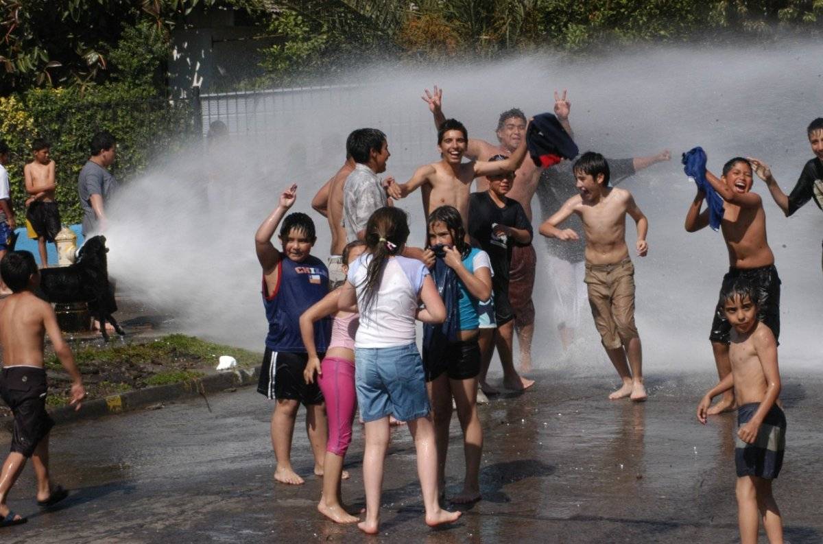 Niños bañándose en el grifo