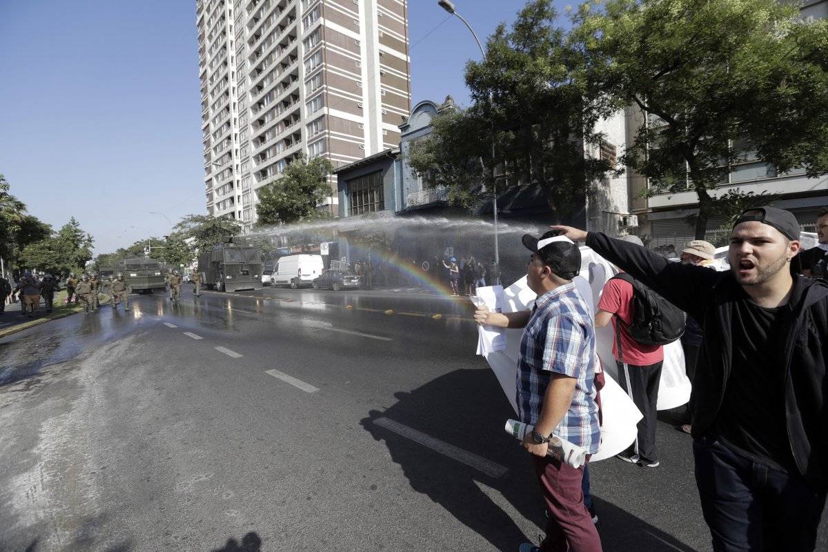 La policía chilena lanza chorros de agua para dispersar una protesta contra la visita del papa Francisco en Santiago de Chile, el martes 16 de enero del 2018. (AP Foto/Víctor R. Caivano)