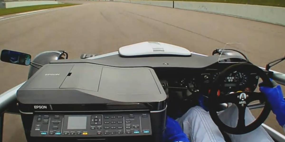 Auto de carreras compite con una impresora en la pista
