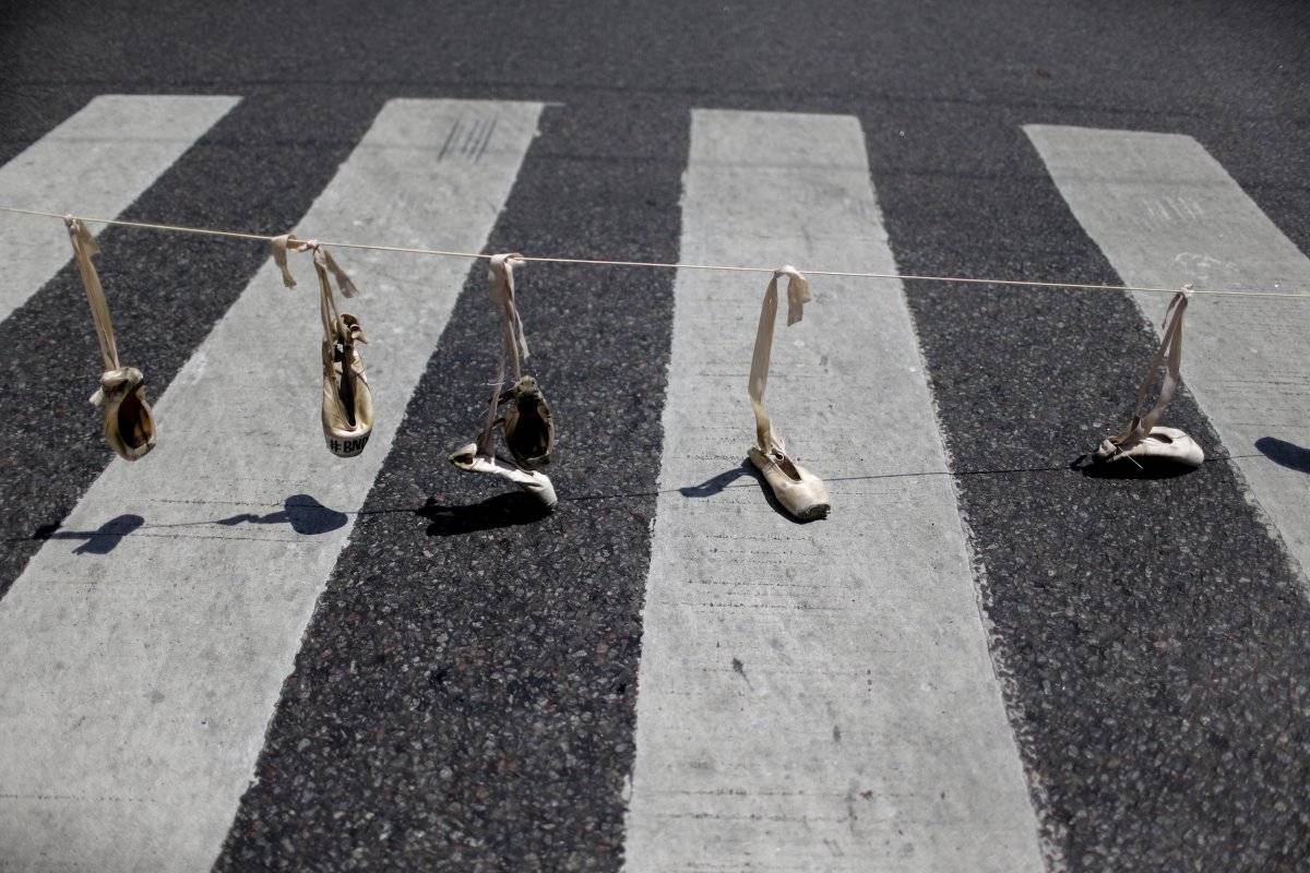 Zapatos de ballet cuelgan de una soga como parte de una protesta contra la reciente decisión de reducir los fondos para la compañía de danza estatal, en Buenos Aires, Argentina. (AP Foto / Natacha Pisarenko)