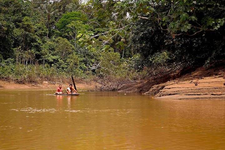 Familia kichwa navegando por el río Tiputini en canoas construidas a mano por los indígenas.