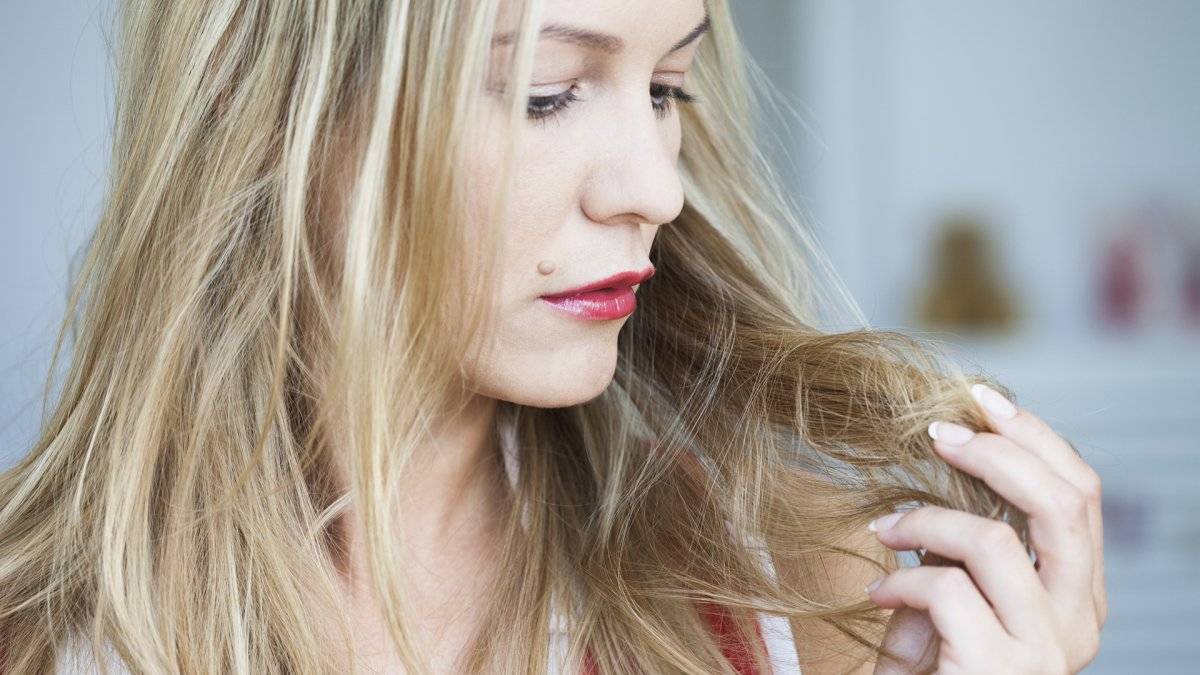 Young woman inspecting her hair