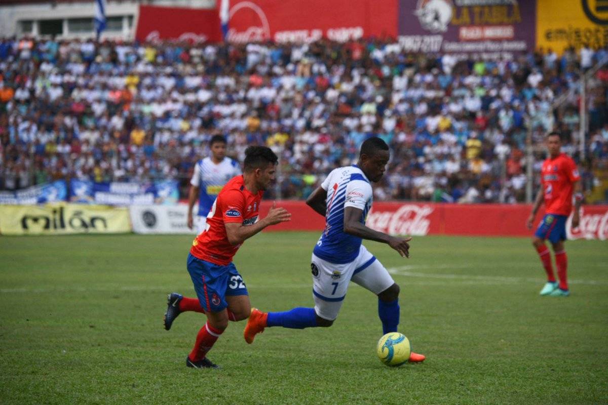 Jose Dos Santos conduce el balón ante Bryan Lemus