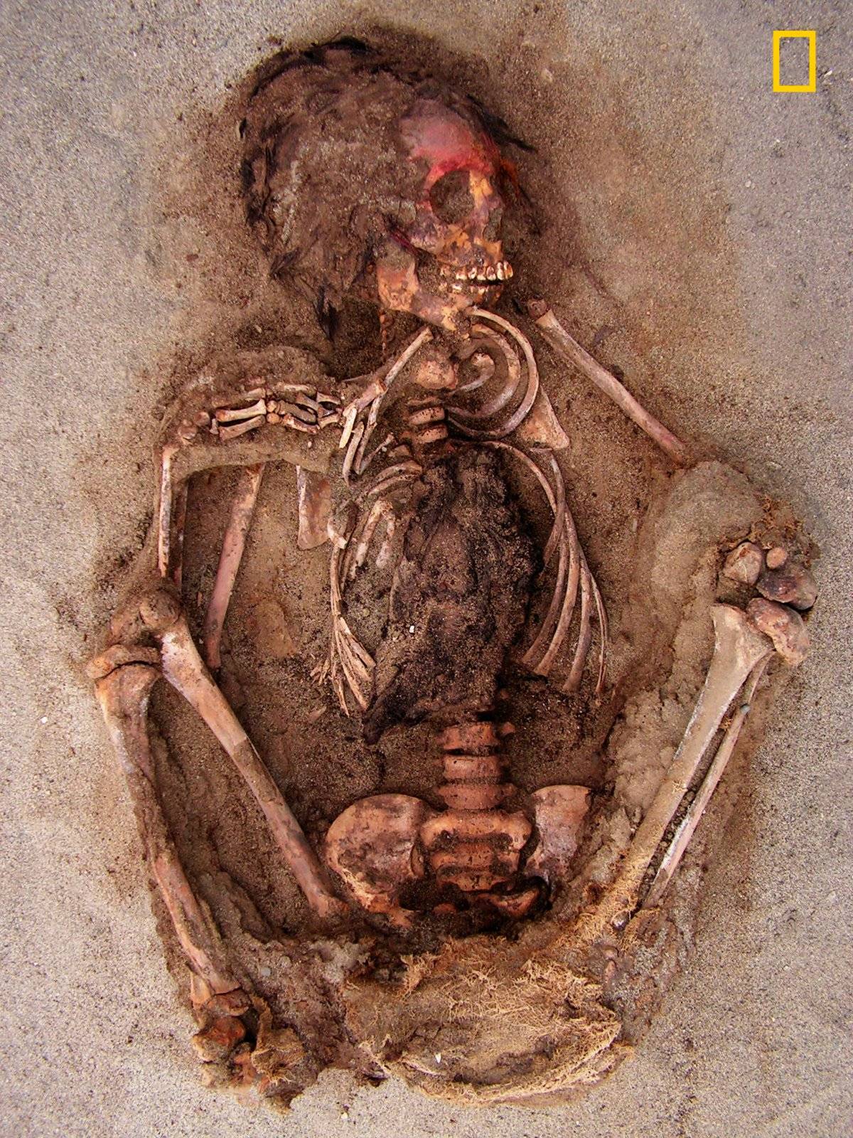 En esta foto del 10 de mayo de 2011 que fue proporcionada por National Geographic, se muestra como la cara de un niño fue pintada con una sustancia roja que contenía cinabrio en Huanchaquito-Las Llamas cerca de Trujillo, Perú.