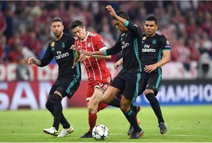 Raphael Varane le quita el balón a Lewandoski