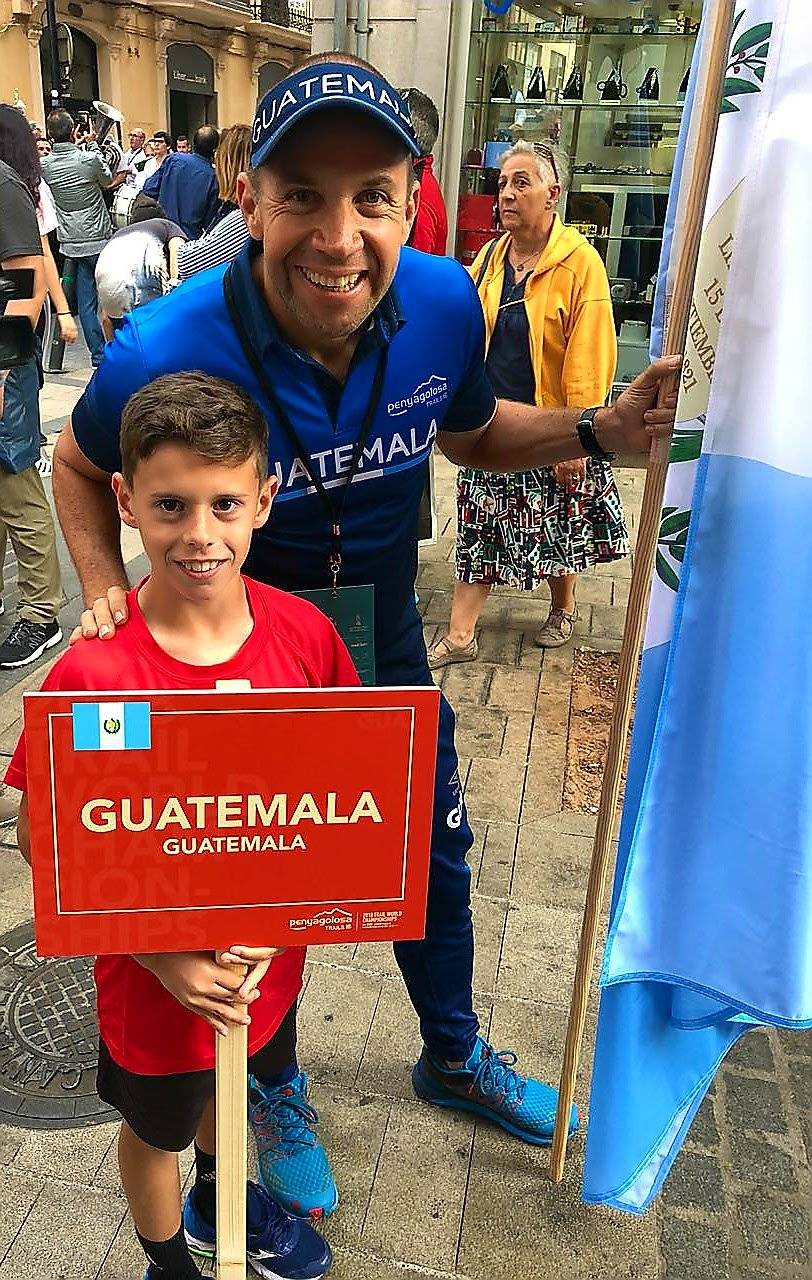 Sagastume junto a un niño que tiene un letrero con el nombre de Guatemala