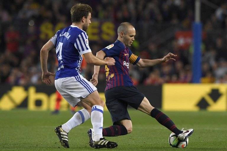 Iniesta protege el balón ante la marca de un adversario