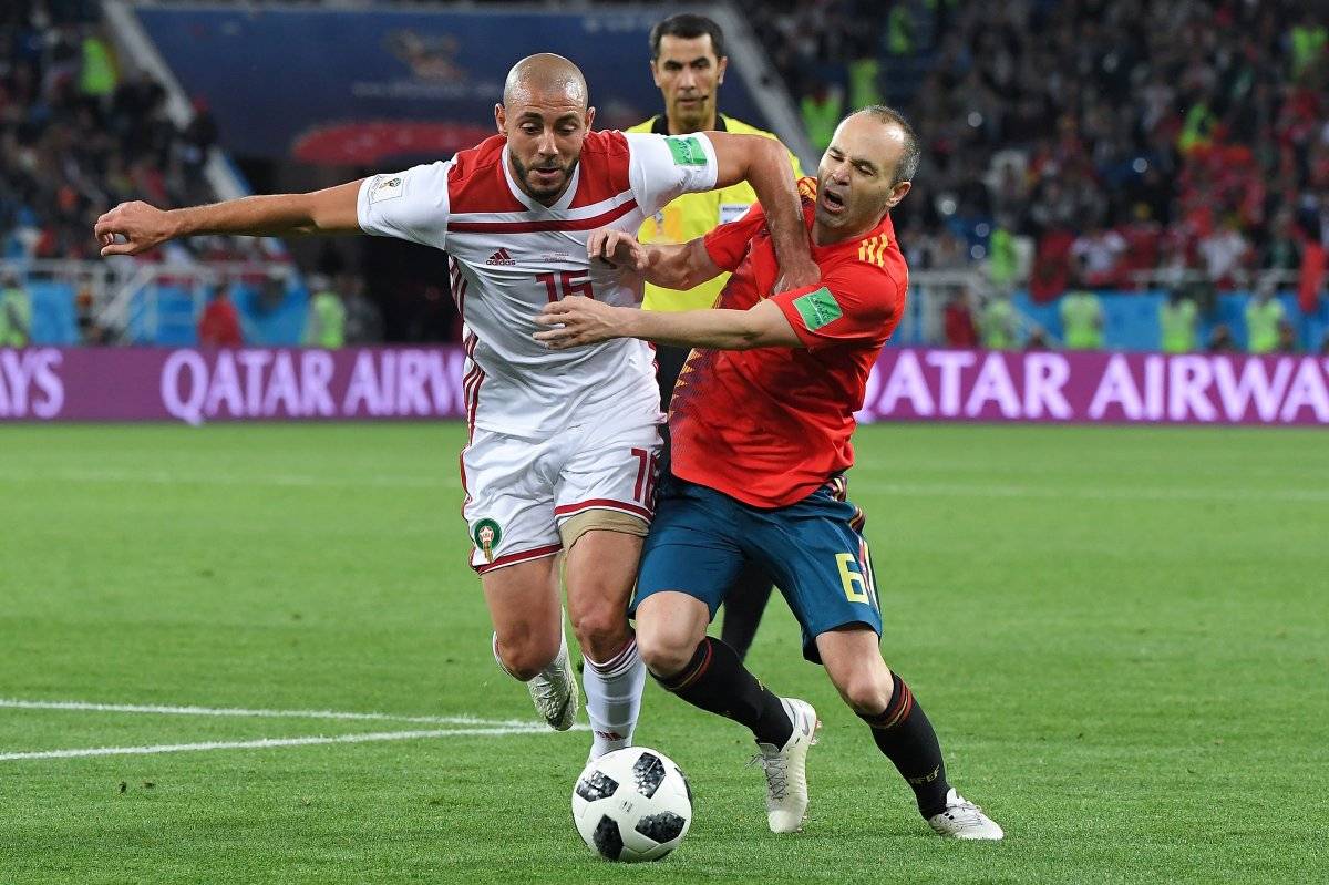 Andrés Iniesta disputa el balón con un rival