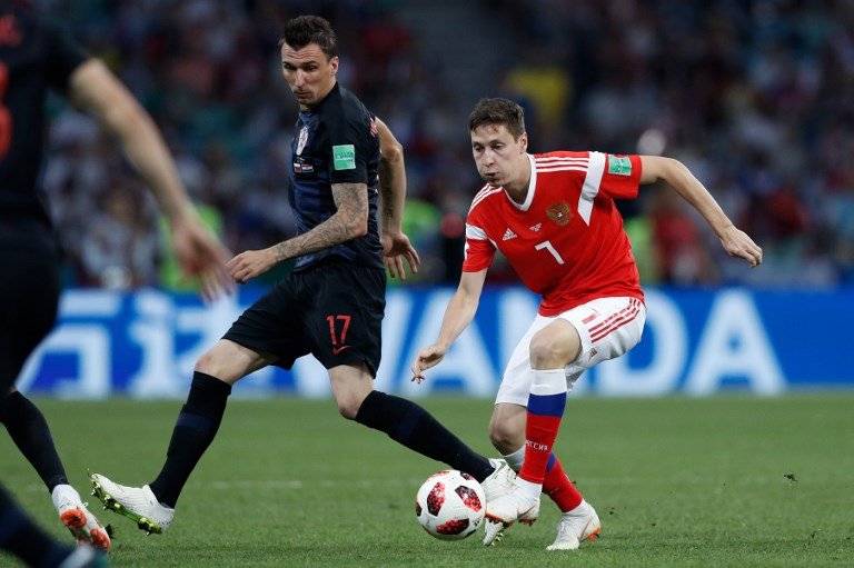 Daler Kuzyaev de Rusia con la posesión del balón ante la presencia de Mandzukic