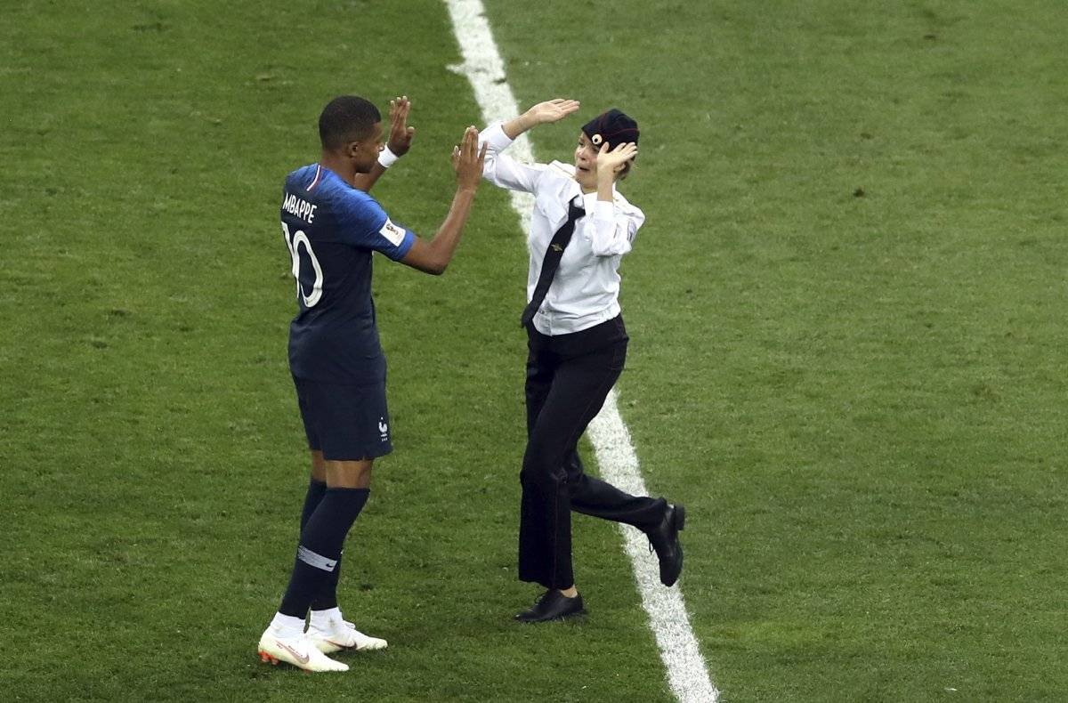 Una de las personas que invadió el terreno de juego saluda a Mbappé