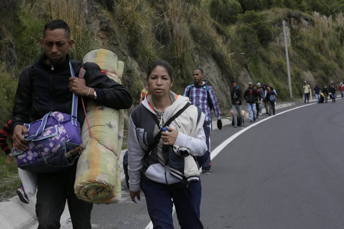 Migrantes venezolanos que no tienen con pasaporte caminan por la carretera Panamericana después de cruzar el puente internacional Rumichaca de Colombia, antes de llegar a un punto de inspección migratoria en Rumichaca,