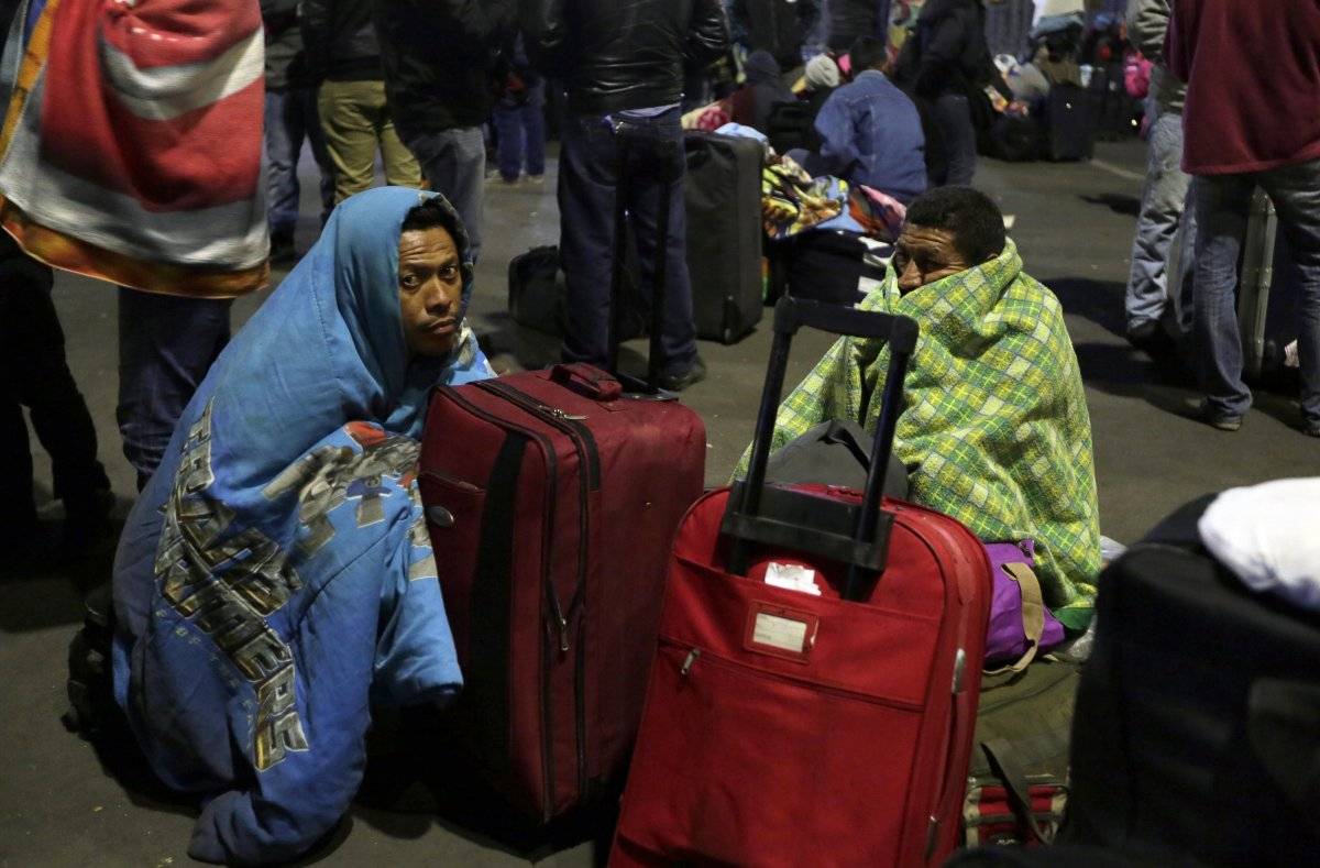Un grupo de migrantes venezolanos espera una decisión de las autoridades de migración que les permita entrar a Ecuador sin pasaporte después de que nuevas regulaciones exigieran el documento en el país en Rumichaca