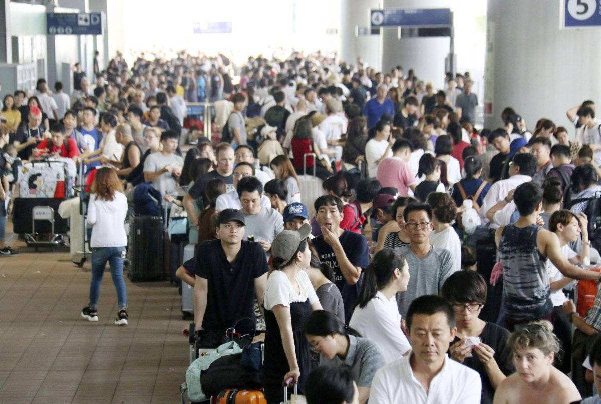 Los pasajeros varados hacen fila para esperar autobuses especiales en el Aeropuerto Internacional de Kansai después del poderoso tifón en Osaka, al oeste de Japón, el miércoles 5 de septiembre de 2018. (Noticias de Kyodo vía AP)