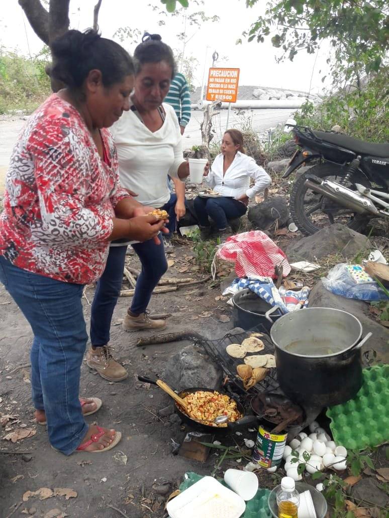 Mujeres cocinan alimentos para comunitarios