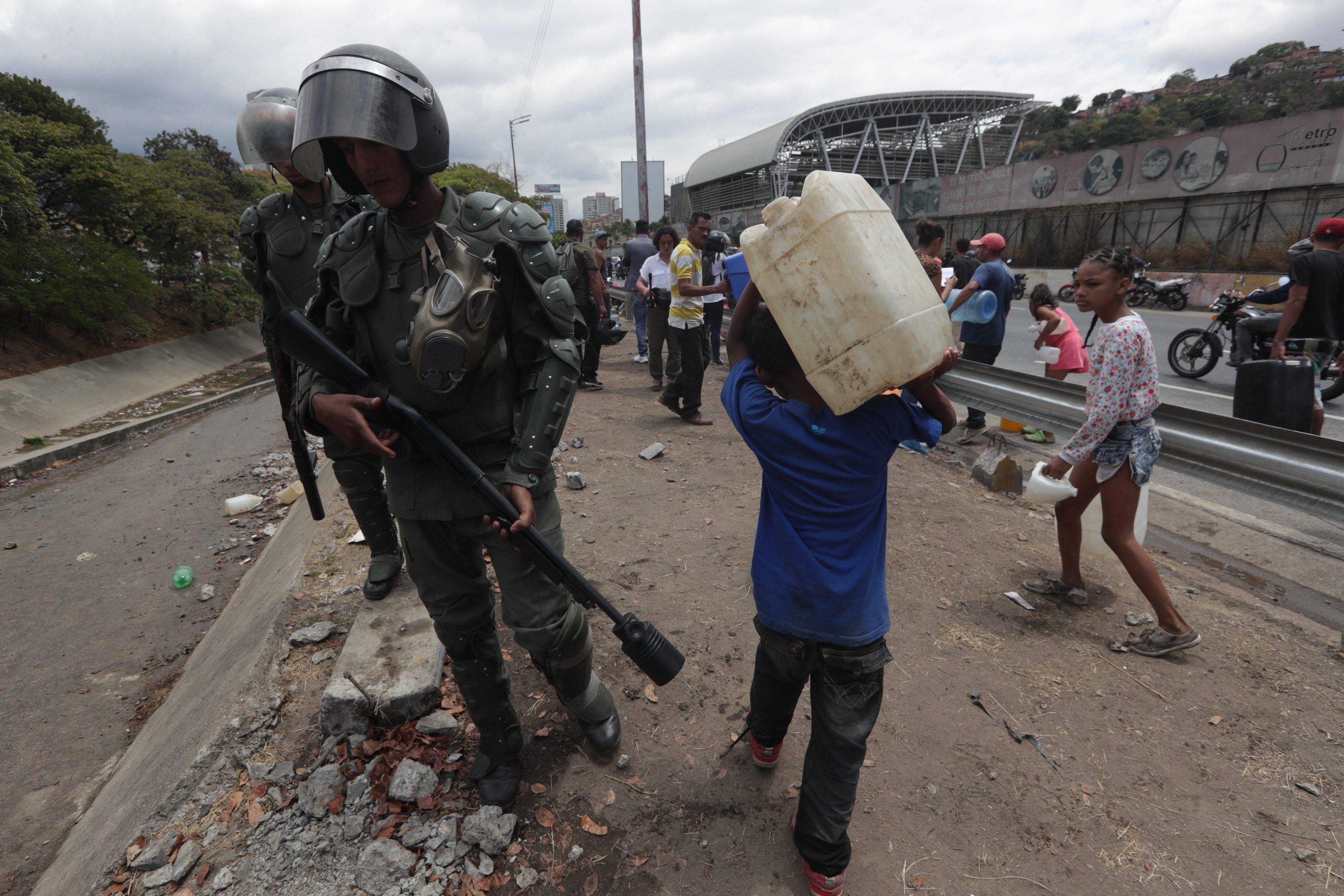Caraqueños recogen agua en el Río Guaire debido a la escasez por apagón en Venezuela