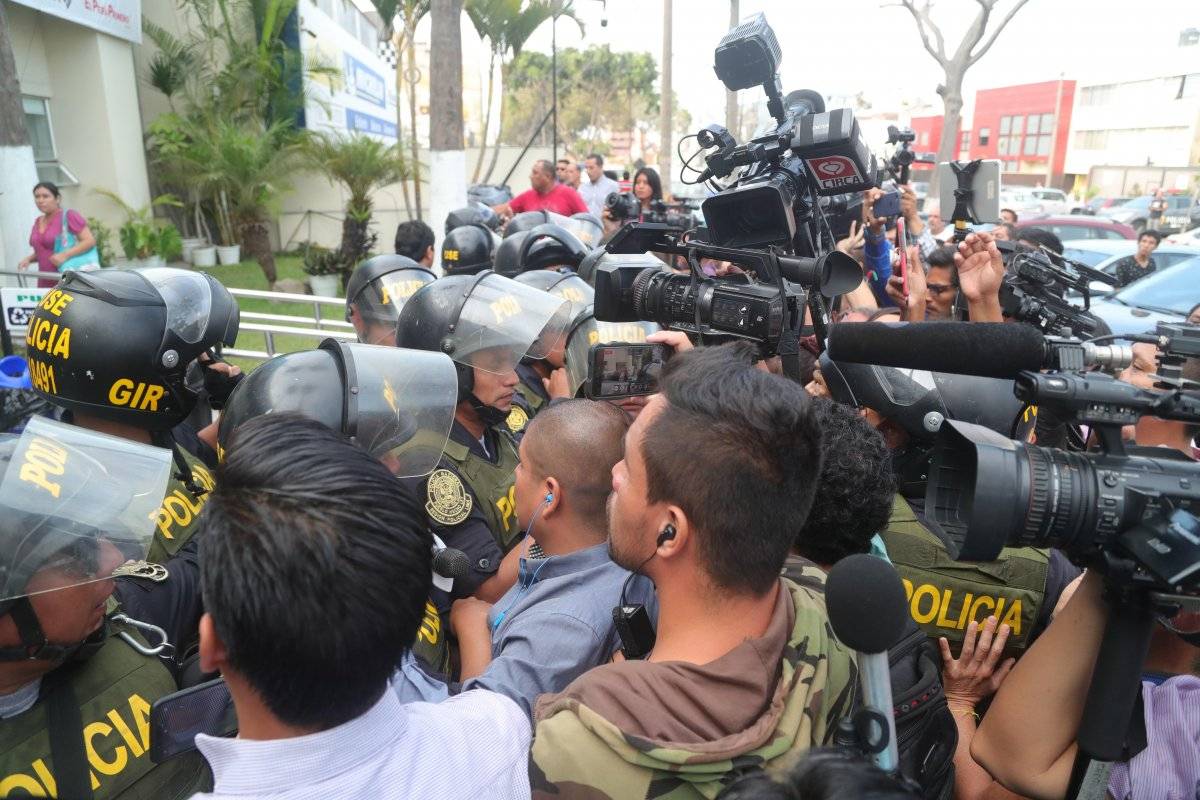 Medios intentan grabar y tomar fotos mientras policías resguardan el hospital Casimiro Ulloa, a donde fue trasladado el expresidente peruano Alan García