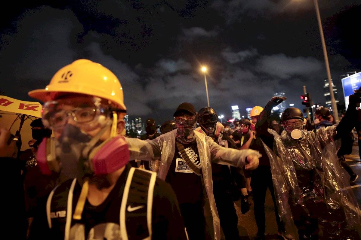 Manifestantes burlan la policía cerca del Edificio de las Fuerzas del Ejército Popular de Liberación de China en Hong Kong, el lunes 2 de septiembre de 2019.