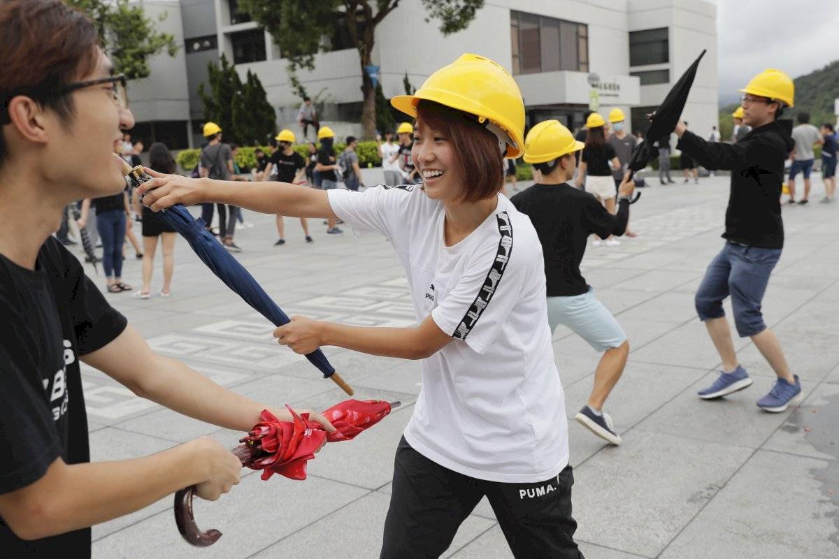 Los estudiantes universitarios usan paraguas para practicar la técnica de defensa personal para evitar posibles actos violentos en Hong Kong