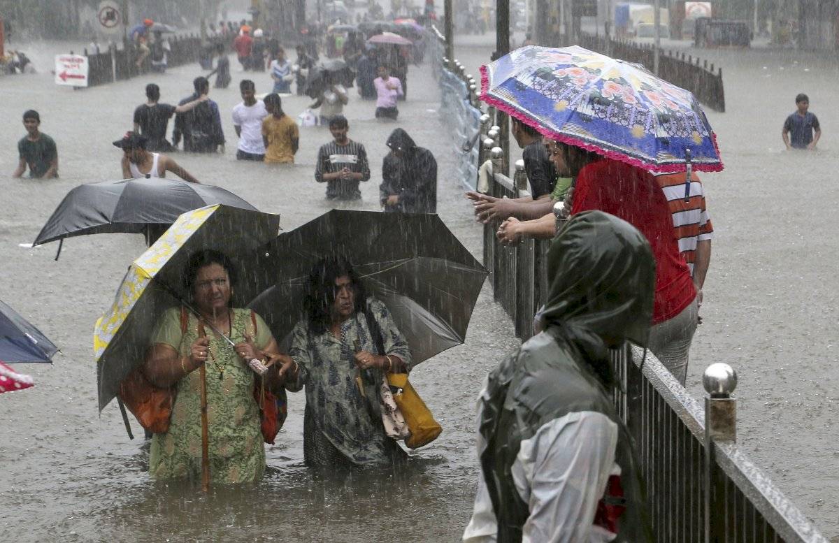 La gente navega a través de una calle inundada mientras llueve en Mumbai, India, el miércoles 4 de septiembre de 2019. La lluvia incesante ha provocado inundaciones en muchas partes de la ciudad, interrumpiendo el movimiento del tráfico y la vida cotidian