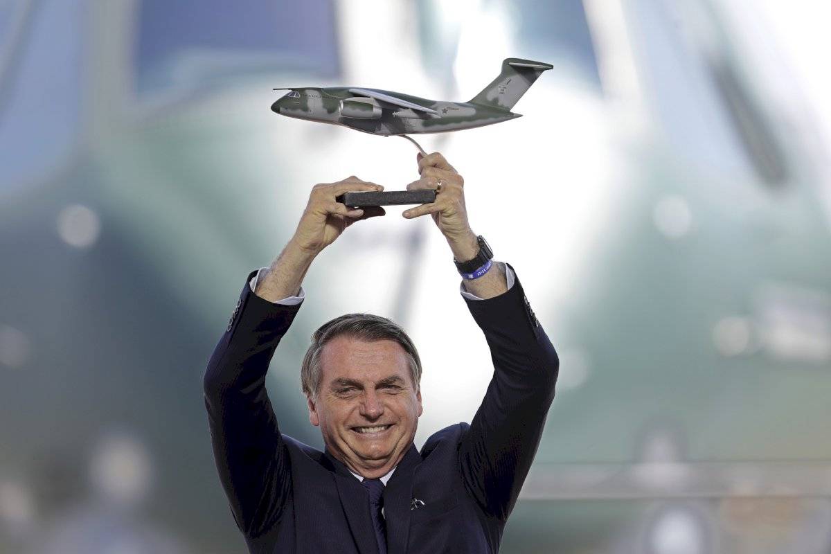 El presidente de Brasil, Jair Bolsonaro, sostiene una miniatura de un avión KC-390 durante la ceremonia de entrega de la Fuerza Aérea de Brasil del primer avión militar KC-390, en la base aérea de Anapolis, Brasil, el miércoles 4 de septiembre de 2019. El