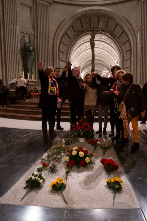 Los visitantes posan para fotos haciendo un saludo fascista por la tumba del dictador Francisco Franco dentro del mausoleo en el