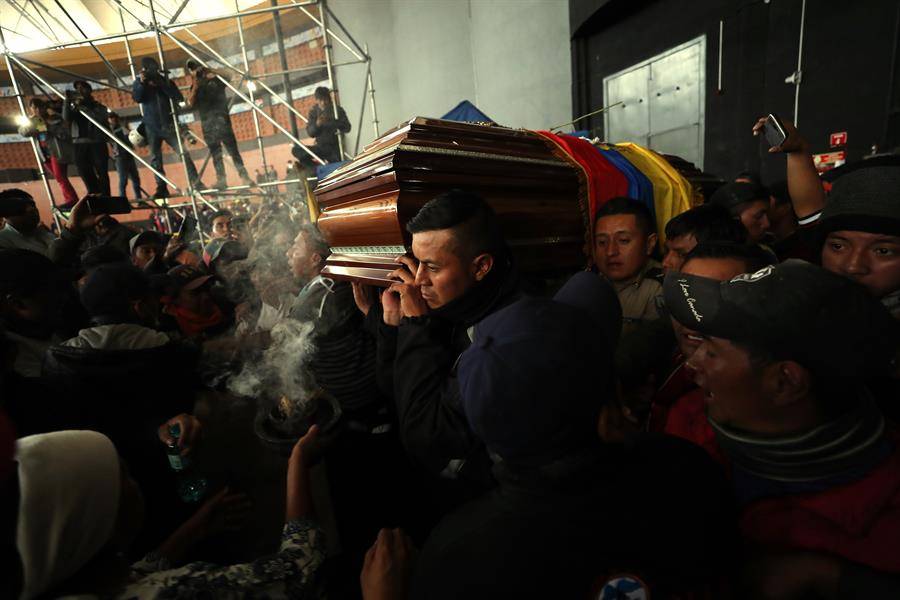 Policías retenidos cargan el féretro del manifestante indígena muerto en choques con la Policía