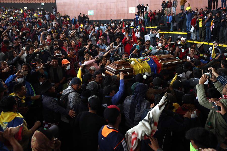 Policías retenidos cargan el féretro del manifestante indígena muerto en choques con la Policía