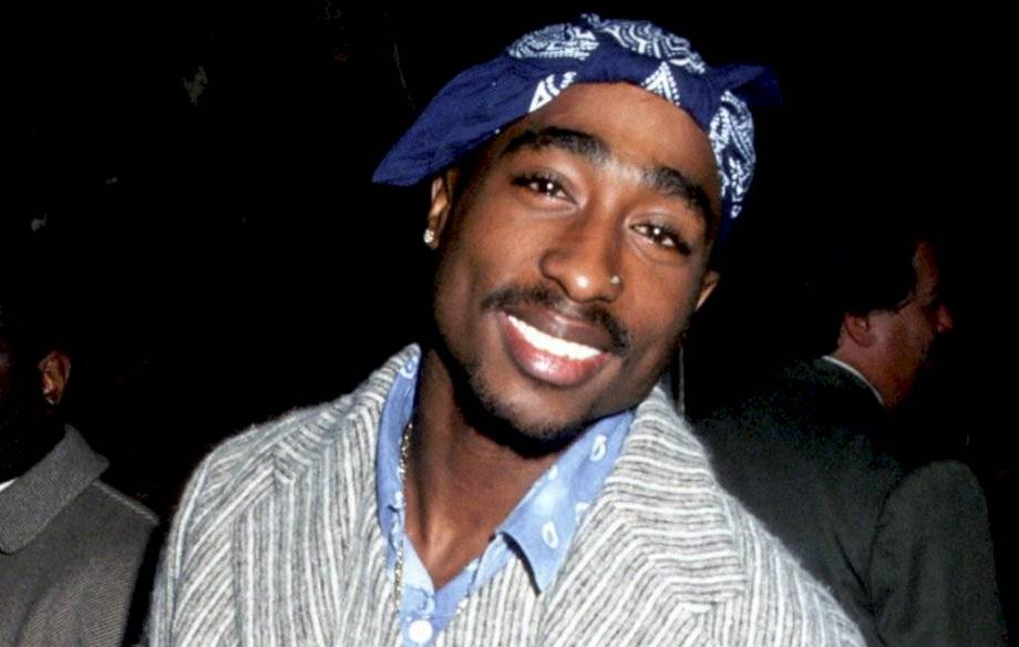 Rapper Tupac Shakur sorri para a câmera