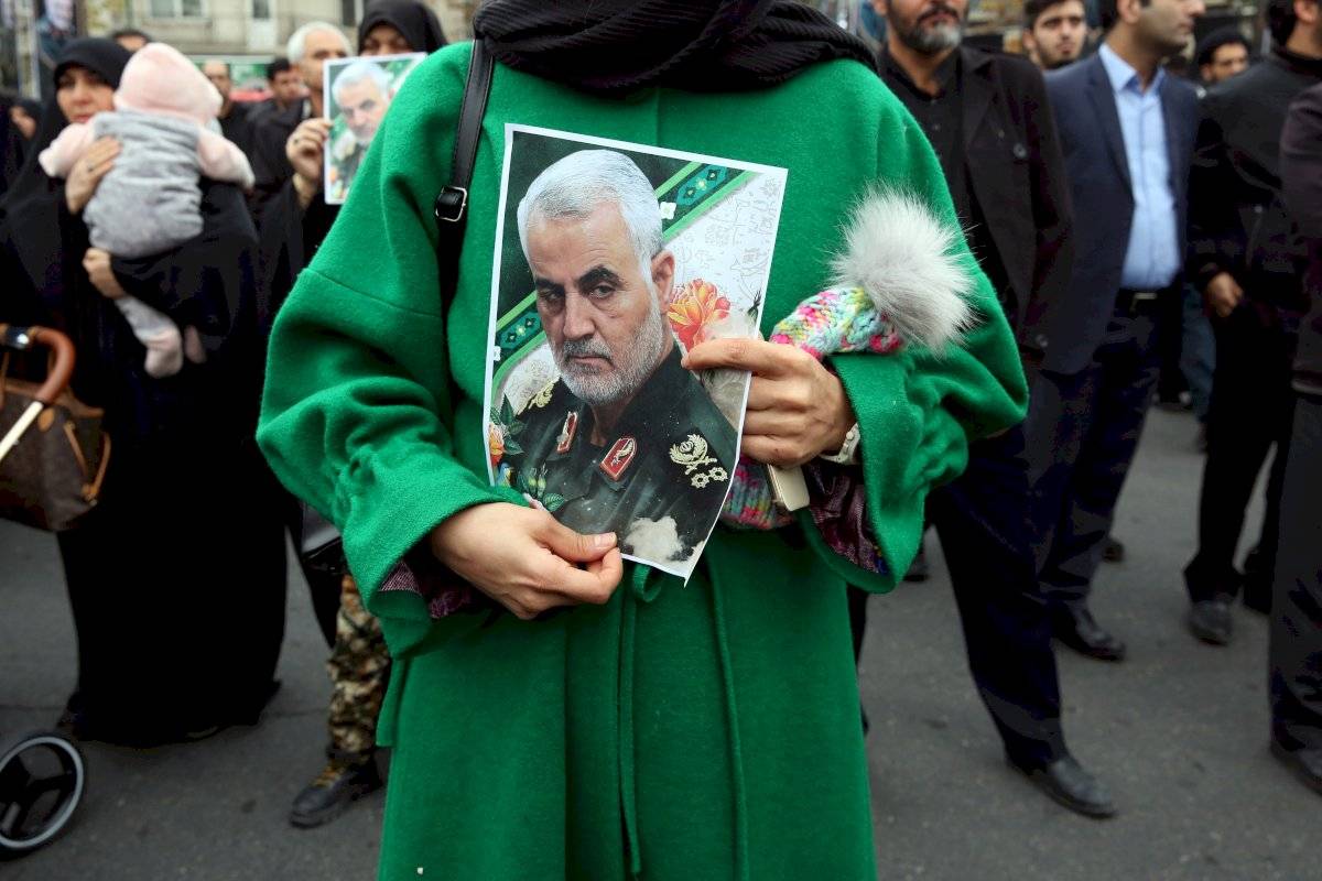 Una mujer iraní sostiene una foto que representa al difunto teniente general del Cuerpo de Guardias Revolucionarios iraníes (IRGC) y comandante de la Fuerza Quds Qasem Soleimani