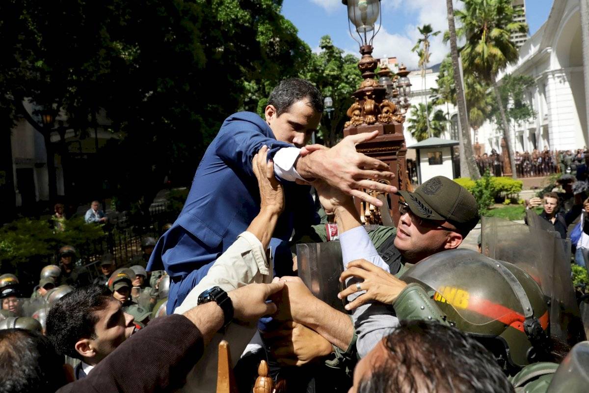 l líder opositor venezolano Juan Guaidó trepa una reja en un intento por ingresar a la sede de la Asamblea Nacional