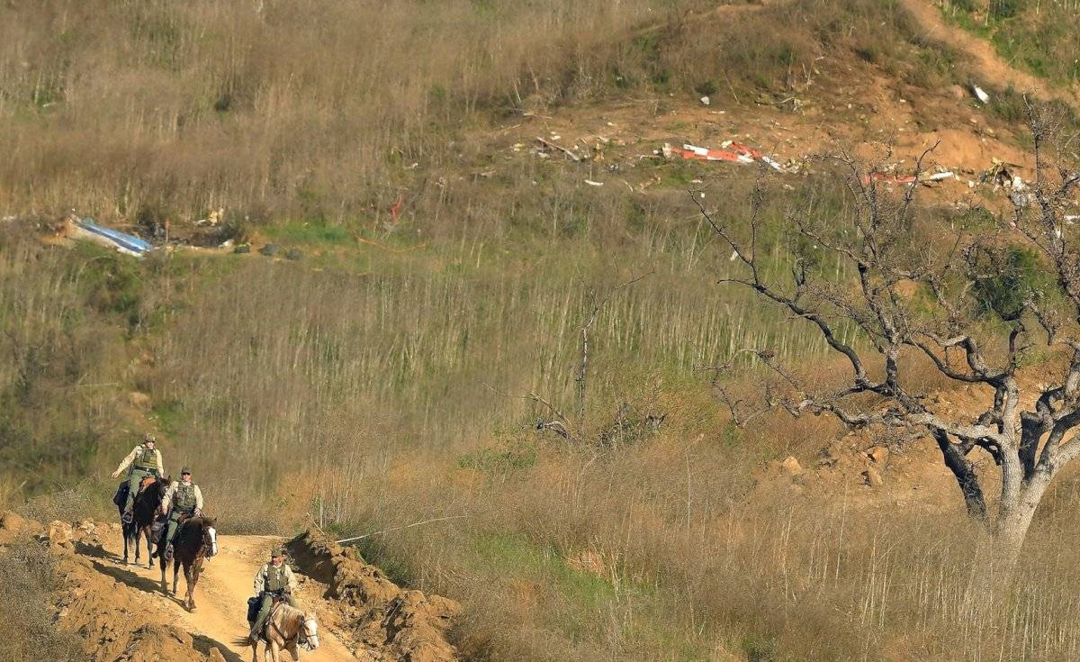 Agentes de la oficina del alguacil se alejan a caballo del lugar donde se estrelló el helicóptero en que murió el exbastquetbolista Kobe Bryant, como parte de las investigaciones sobre el desastre, el lunes 27 de enero de 2020