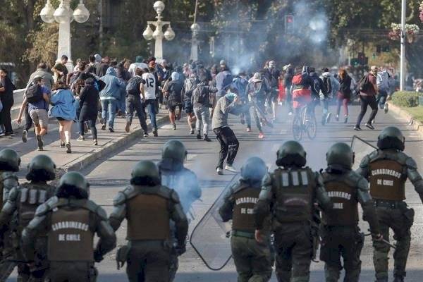 Manifestantes se enfrentan con la Policía durante protestas contra la realización del festival de Viña del Mar