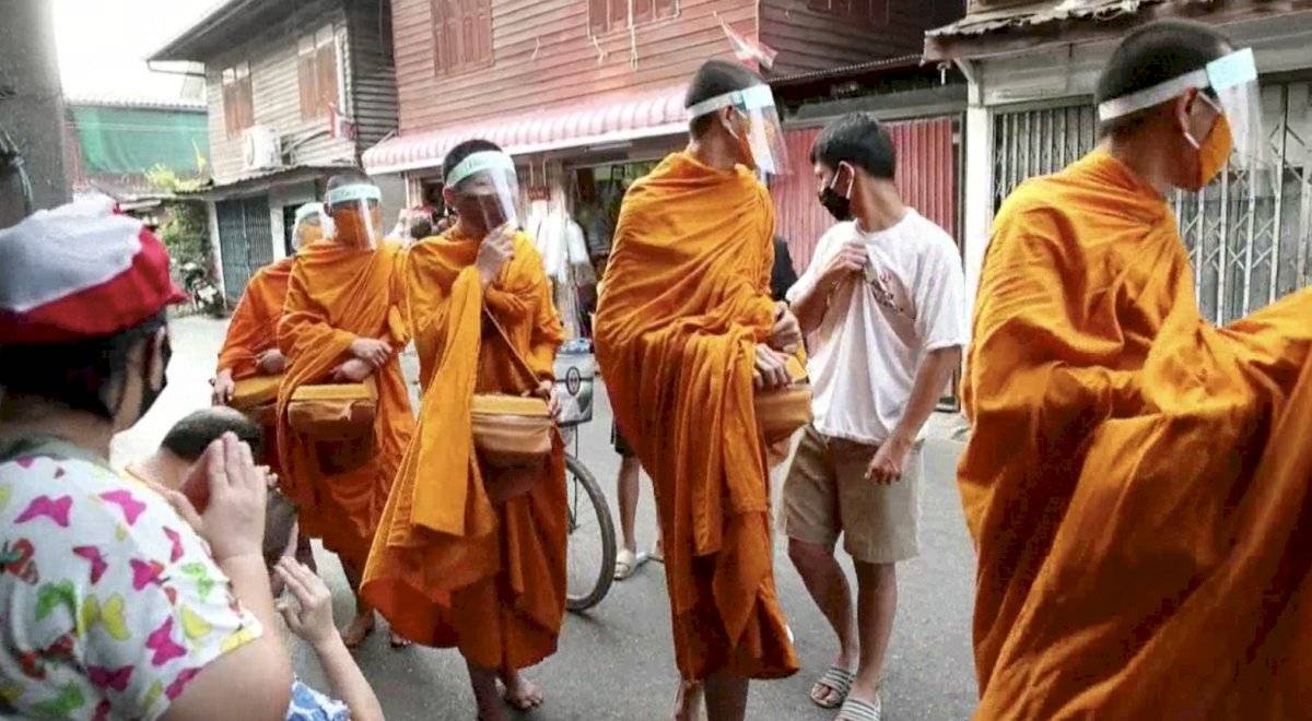 Monjes budistas en Bangkok salen a recibir limosna con mascarillas por el coronavirus