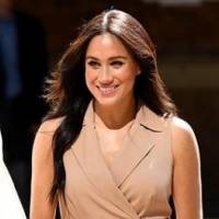 Meghan Markle luce cómoda y elegante en un vestido de mezclilla con un maxi cárdigan blanco
