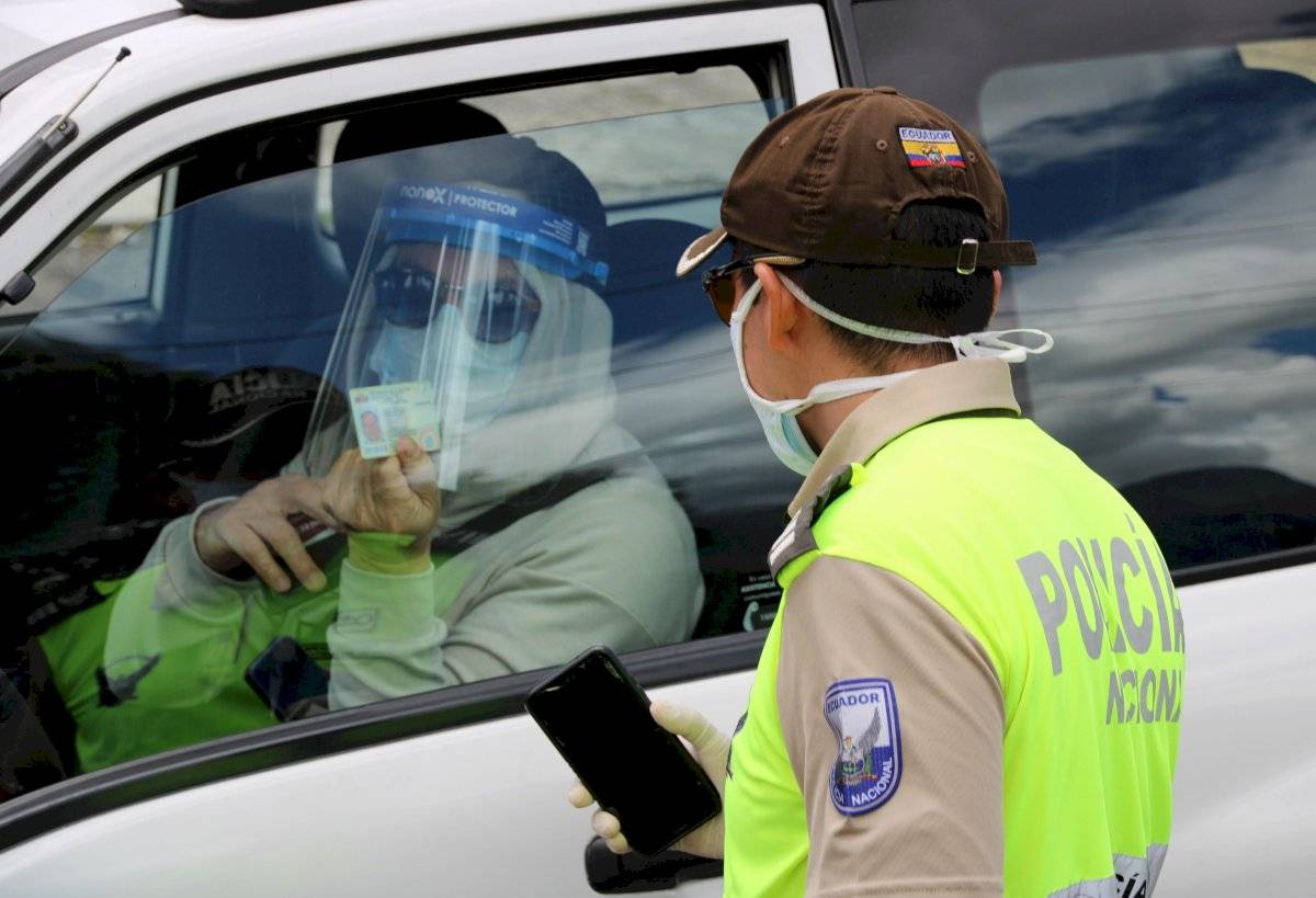 Agentes de la Policía Nacional revisan este domingo los documentos de conductores, en un puesto control en una de las avenidas del norte de Quito