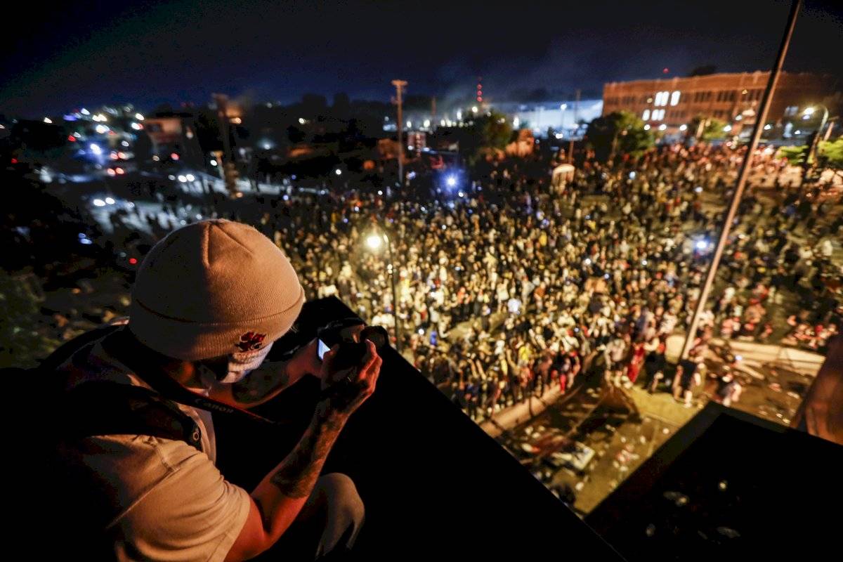 Un manifestante toma una foto de una manifestación desde el techo del tercer recinto policial de Minneapolis, el jueves 28 de mayo de 2020, en Minneapolis.