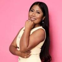 Yalitza Aparicio posa en pijama desde su sencilla sala de estar con sillón gris, plantas y mesa de cristal