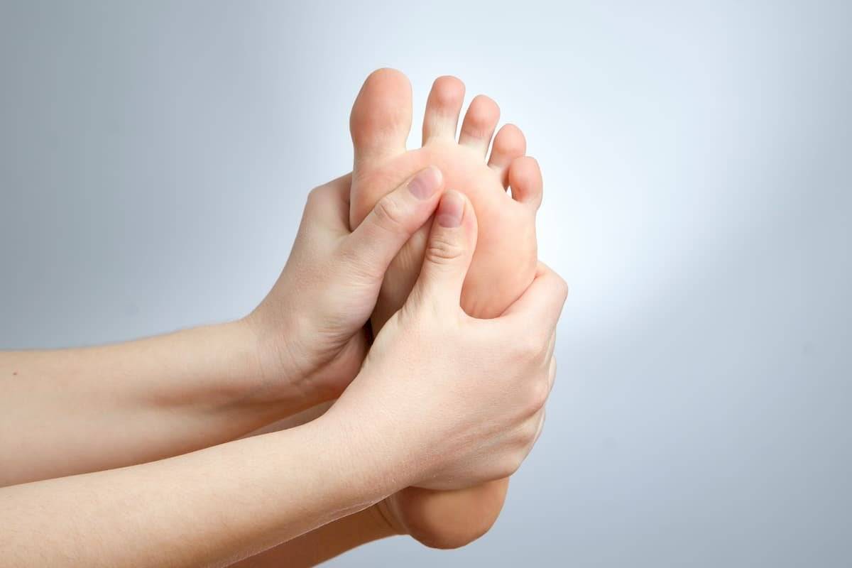 Masajea los pies con una crema hidratante