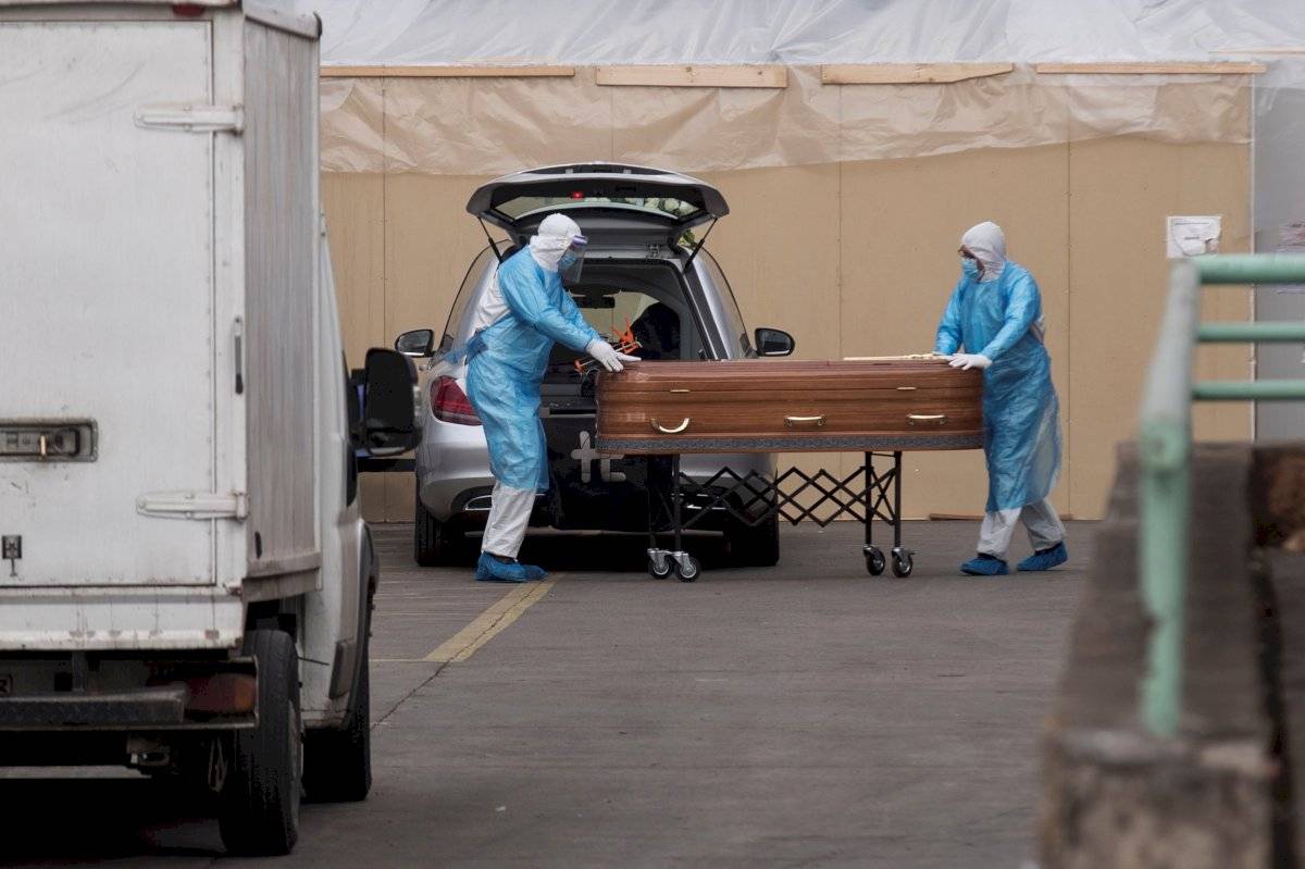 Trabajadores de una funeraria cargan un ataúd este viernes en el Hospital San José en Santiago