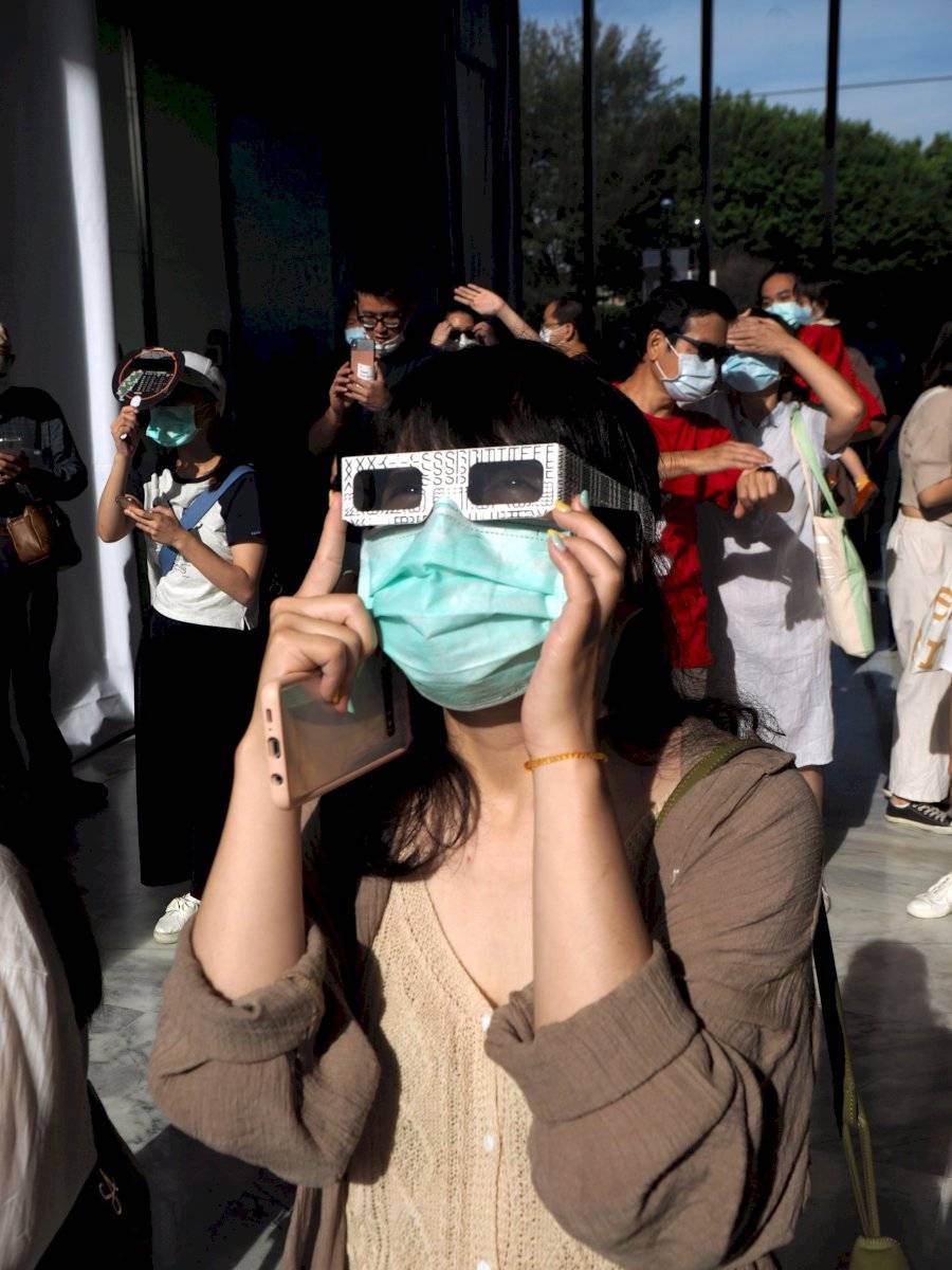 Una mujer ve el sol usando gafas protectoras especiales durante un eclipse solar anular parcial en Taipei, Taiwán, el 21 de junio de 2020